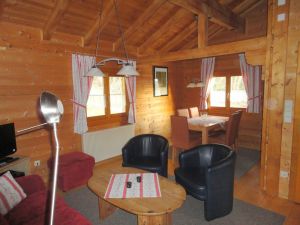Für die Mahlzeiten stehen im Eßbereich ein großer Tisch und 5 Stühle bereit.
Im oberen Teil ist die offene Holzkonstruktion des Daches zu sehen.