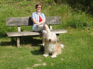 Pause im Park Frauchen und Kaja genießen die Sonne auf einer Bank im Ferienpark.