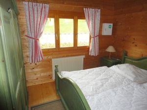 Für einen guten Schlaf sorgt das bequeme Doppelbett im alpenländischen Stil. Für viel Stauraum gibt es den großen Kleiderschrank.