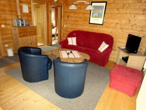 Vom Wohnzimmer aus gelangt man in sämtliche Räume des Hauses. Neben der Sitzgarnitur mit Couchtisch steht der Flachbildschirm des SAT-Anschlusses und im darunter befindlichen Schrank Videorekorder und DVD-Player.
