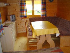 Ausziehbarer Eßtisch mit Eckbank und Stühlen. Links ein Sideboard mit Mini-Stereoanlage.
