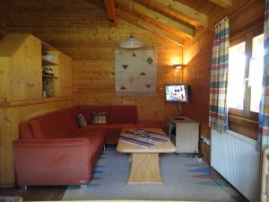 Sitzgruppe, Couchtisch, Flachbildfernseher (SAT)und Fernsehunterschrank mit Videorecorder und DVD-Player. Link befindet sich der Raumteiler mit Schrankelementen.
