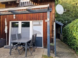 Überdachte Terrasse mit Sonnenschirm, Sitzgelegenheit und Grill
