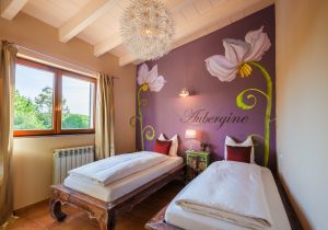 Das große Doppelzimmer Aubergine hat zwei getrennte Betten und ist besonders beliebt bei unseren weiblichen Gästen. Freundinnen-Urlaub, Schwestern-Auszeit oder Mutter-Tochter-Tage – die Farbgestaltung und der direkte Zugang zur großen Dachterrasse mit Blick auf Pool und Garten sind einfach top!