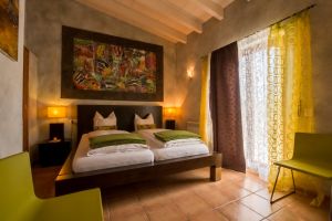 Das große Doppelzimmer Olive gehört zu den Favoriten unserer Gäste. Elegant eingerichtet verfügt „Olive“ über einen direkten Zugang zur großen Dachterrasse mit Blick auf den Pool und unsere (Obst-)Gärten. Das Zimmer ist sehr geräumig und hat ein Kingsize-Bett mit 2 Matratzen (90x200 cm). Die besondere Wandmalerei über dem Bett wurde von der Vorbesitzerin aus der Schweiz mit viel Liebe gestaltet.