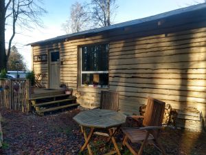 eingezäunter Außenbereich mit Sitzmöglichkeiten und Grill