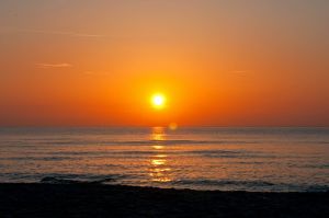 Im Sommer geht die Sonne direkt über dem Meer unter.
